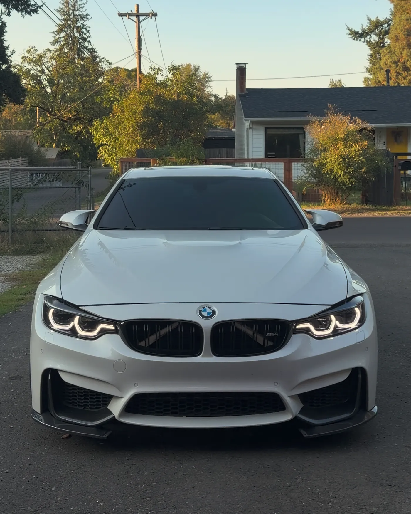 White BMW F82 M4 at golden hour after an Ikon headlight install at PDXEuroWerks, a Portland BMW performance shop in Oregon