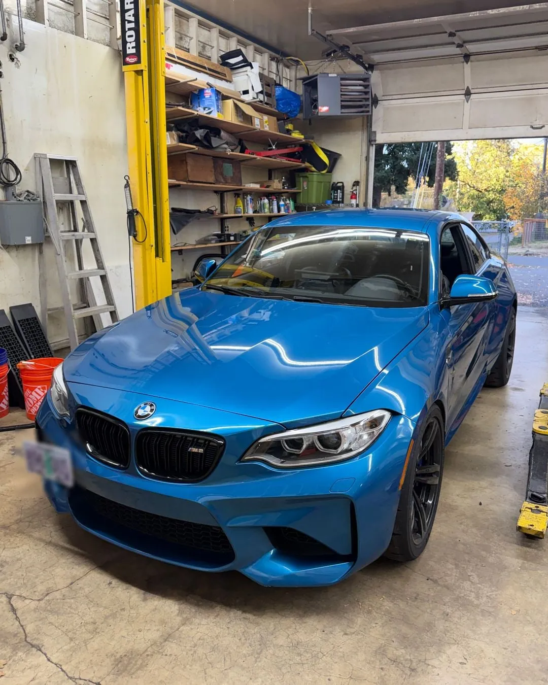 BMW exhaust leak diagnostic and repair in Portland, OR: a blue F87 M2 getting the downpipe clamp a previous shop left off, at PDXEuroWerks