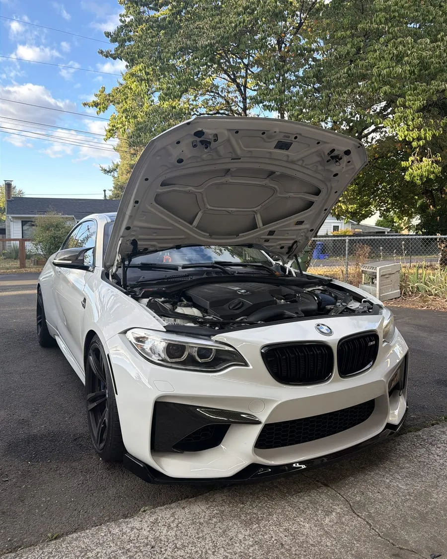 White BMW F87 M2 with the hood up for an intercooler install and tune flash at PDXEuroWerks, a Portland BMW performance shop in Oregon