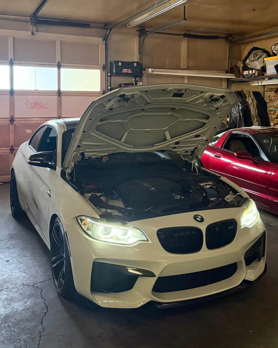 White BMW F87 M2 with the hood up for an intercooler install and tune flash at PDXEuroWerks, a Portland BMW performance shop in Oregon