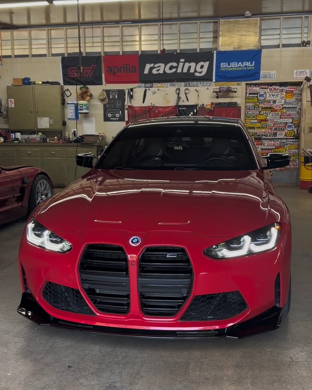 Red BMW G80 M3 Competition 50 Jahre Edition after a front splitter install at PDXEuroWerks, a Portland BMW specialty shop in Oregon