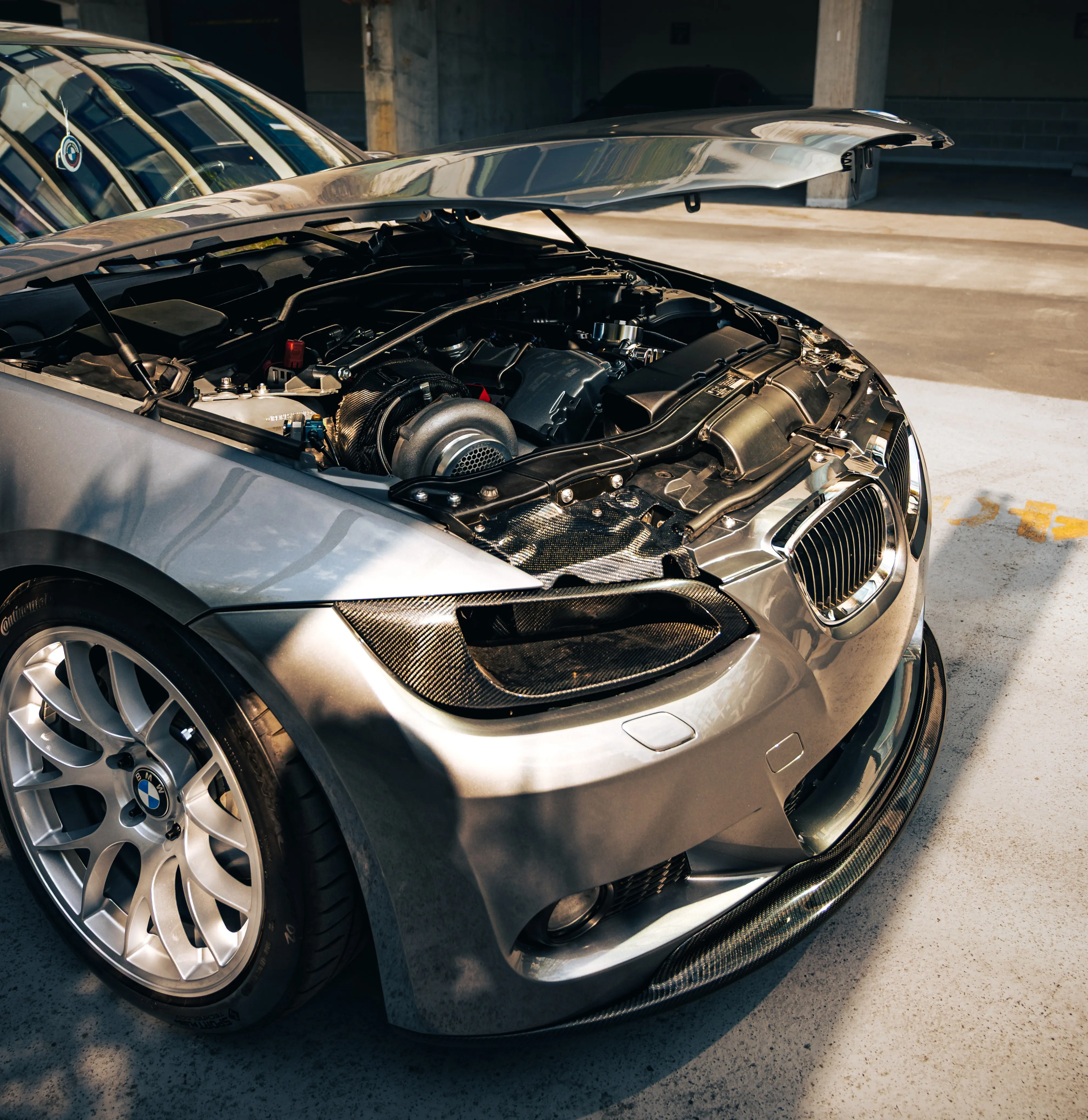 BMW downpipe install and single-turbo conversion in progress on an E92 335i engine bay at PDXEuroWerks in Portland, Oregon